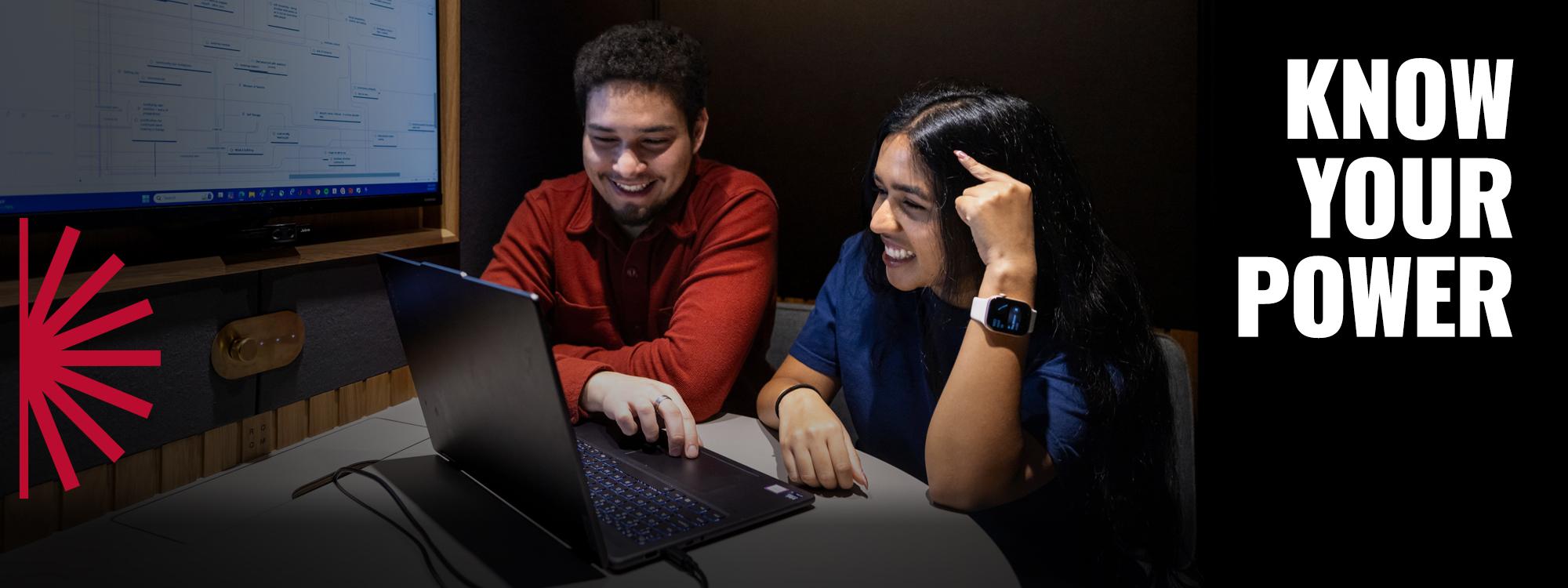 Know your power text with two students looking at a laptop