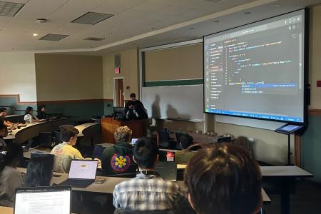 SoC students discussing code at UGAHacks9 event.